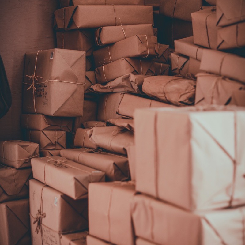A wall of finished parcels in brown paper, each one tied off with fine string