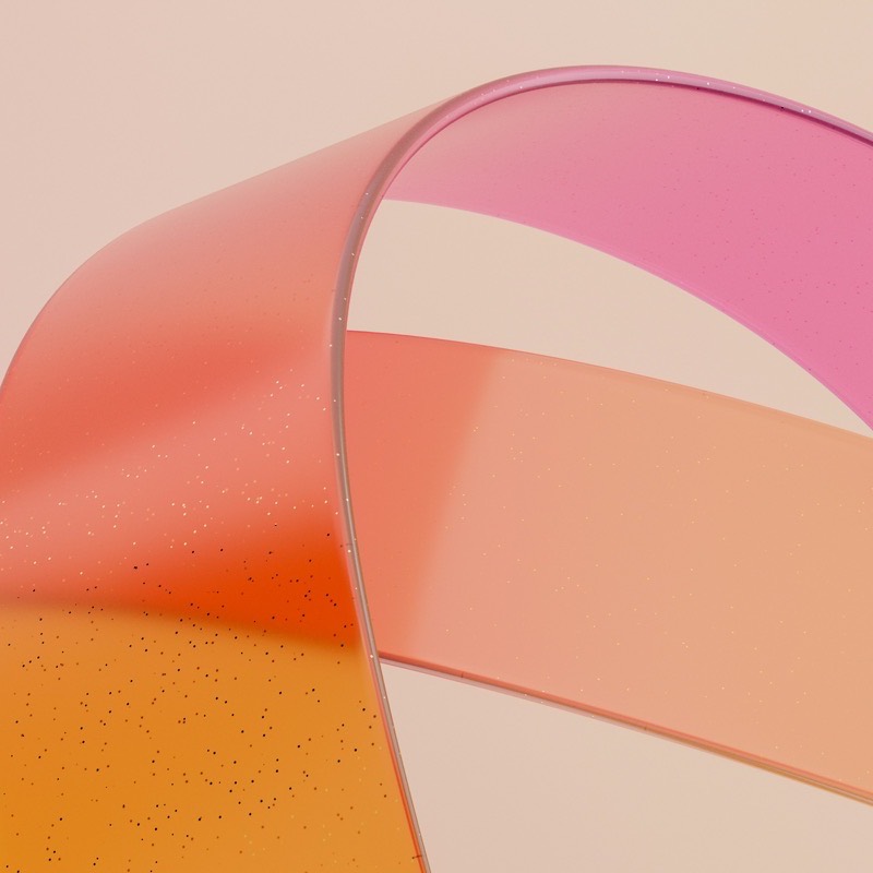 A wide satin ribbon pulled taut in a curve across a warm blush surface