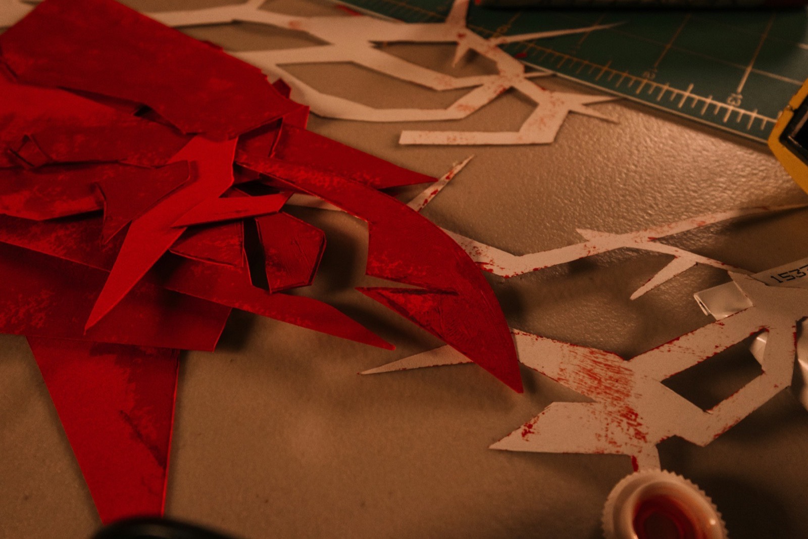 A wrapping bench seen from above with offcuts, tape and a coil of red ribbon